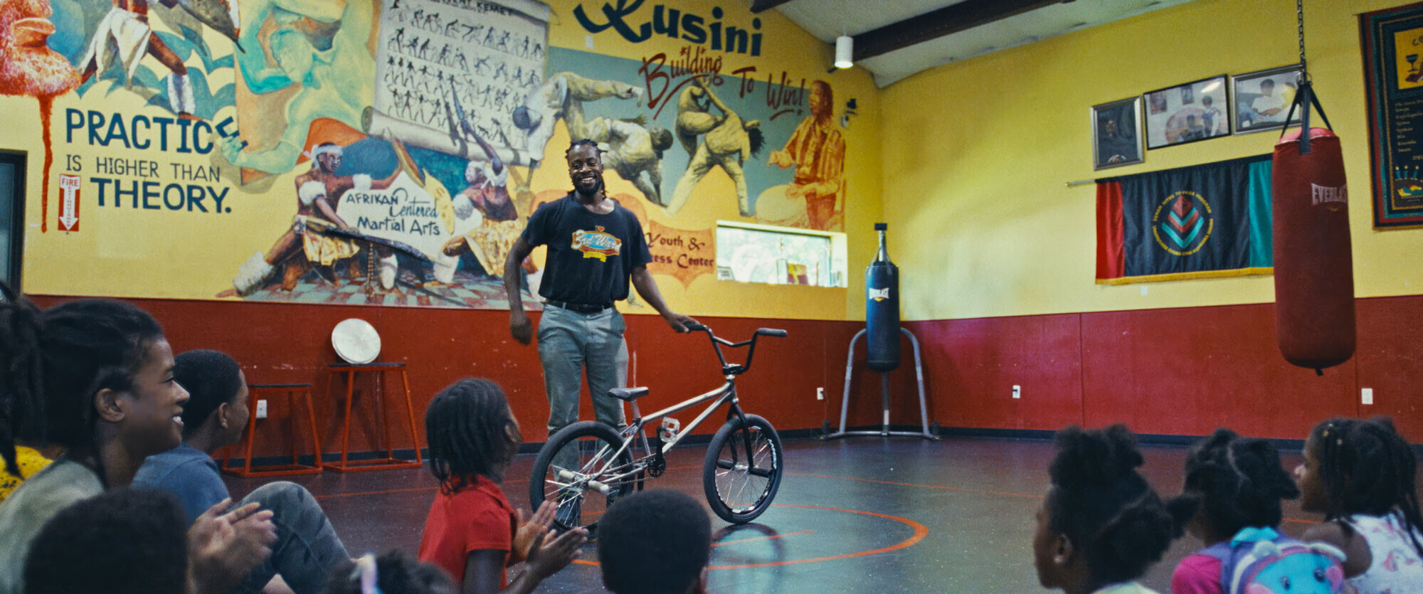 Omari Cato zeigt Kindern in einem Gemeindezentrum seine BMX-K&uuml;nste und begeistert damit junge Fahrer.